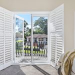 Shutters in a room letting lots of natural light in the bedroom